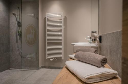 łazienka z prysznicem, umywalką i ręcznikami w obiekcie Ruhehotel & Naturresort Rehbach - Adults only w mieście Schattwald