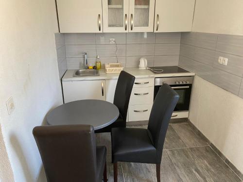 une petite cuisine avec une table, des chaises et un évier dans l'établissement Villa Behar, à Gnojnice