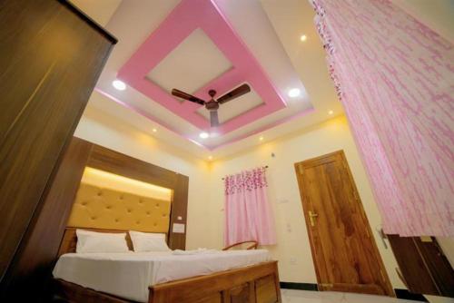 DEVSINN LODGE في Vadakku Valliyūr: غرفة نوم مع سرير بسقف وردي