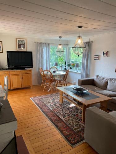 a living room with a couch and a table at Nice child-friendly house 200m from beautiful beach,near Kullaberg in Farhult