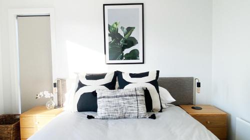 a bedroom with a bed with black and white pillows at Burrows Hutch Wanaka in Albert Town