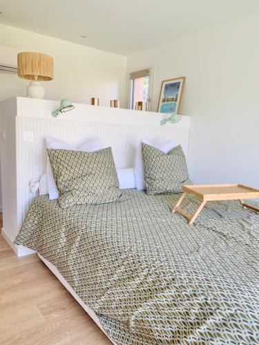 un lit avec des oreillers et une table dans une chambre dans l'établissement Le Petit Mas Roc, à Saint-Maximin-la-Sainte-Baume