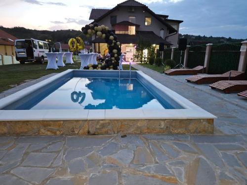 una piscina en un patio con una mesa y una mesa en Apartmani Apolon, en Vrdnik