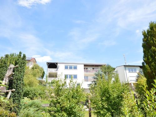 un edificio blanco con árboles delante de él en Delightful Villa in Gerolstein with Private Garden, en Gerolstein