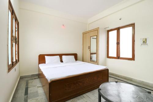 1 dormitorio con cama y mesa de cristal en Hotel Bhameshwari Haridwar Near Bharat Mata Mandir - Prime Location - Excellent Service, en Haridwar