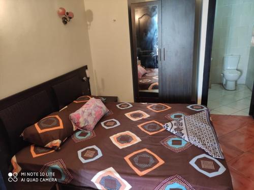 ein Schlafzimmer mit einem Bett mit einer Steppdecke darauf in der Unterkunft شاليه في بورتو مارينا in El-Alamein