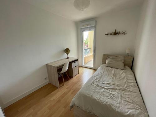 une chambre avec un lit, un bureau et une fenêtre dans l'établissement Appartement T3 à Bayonne avec terrasse de 14 m2, à Bayonne