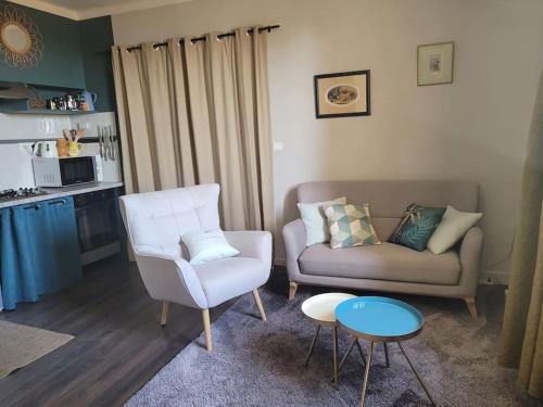 ein Wohnzimmer mit einem Sofa und einem Stuhl in der Unterkunft Maison de village panoramique in Châteauneuf-du-Pape