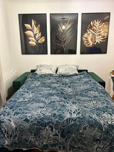 - un lit dans un dortoir avec 4 photos sur le mur dans l'établissement Le floral, à Carcassonne