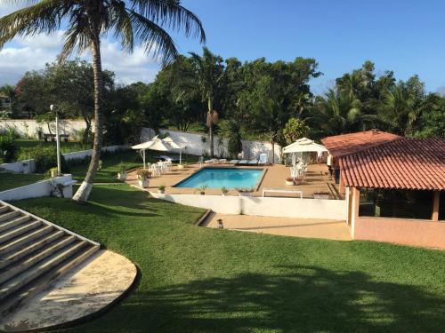 a backyard with a swimming pool and a house at Pousada Doce Vida Guarapari in Guarapari