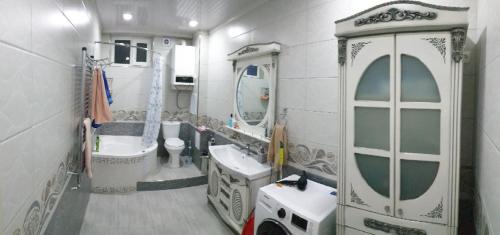 ein Badezimmer mit zwei Waschbecken, einem WC und einem Spiegel in der Unterkunft Апартамент в элитном районе in Andijon