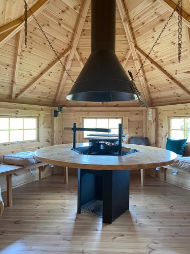 una gran cocina con mesa en una habitación de madera en Maison bois kota / bain nordique / proche de la mer / kota grill, en Longueil