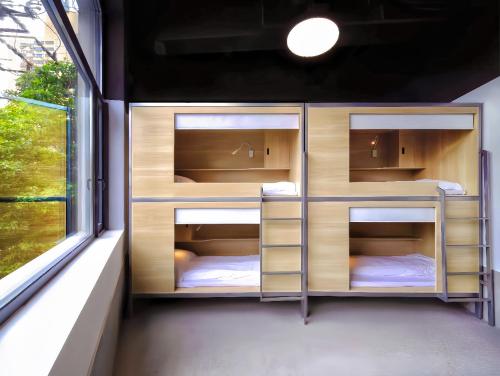 a room with three bunk beds in it with a window at WeFlow Youth Hostel - Shanghai People's Square Jing'an Joy City in Shanghai