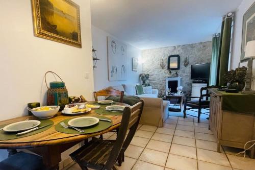 a dining room and living room with a wooden table at Maison de charme d'Ile de France in Chaumontel