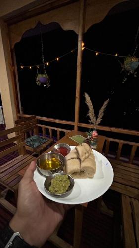 BanjārにあるMOZO Inn&Cafe Jibhiの食卓の皿を持つ者