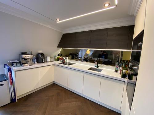 a kitchen with white cabinets and a counter top at Beautiful Penthouse in centre of Winchester in Winchester