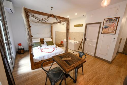 Un dormitorio con una cama y una mesa con sillas. en Amourette à Sète, en Sète