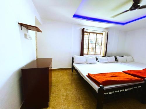 a bedroom with two beds and a blue ceiling at Deluxe Residency in Kalpetta