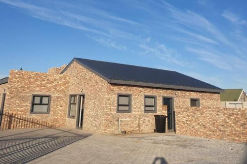 a large brick building with a black roof at Saldeseas in Strandfontein