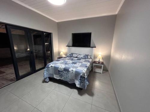 a bedroom with a bed and a flat screen tv at Saldeseas in Strandfontein