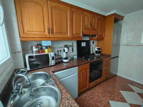 a kitchen with a sink and a microwave at Paul's Rooms, no se admiten turistas not for tourists in Valencia