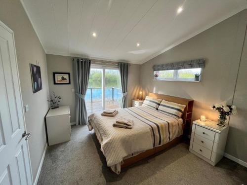 a bedroom with a large bed and a window at Waterside Retreat Heron Lakes Nr Beverley in Beverley