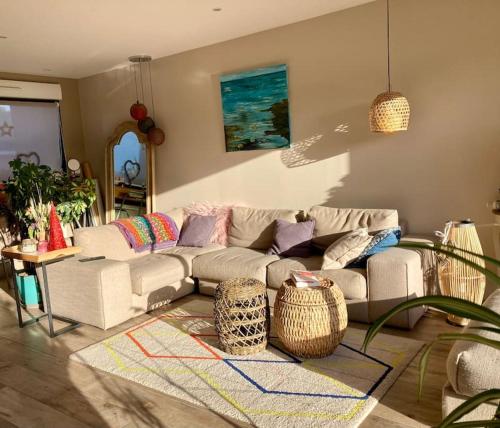 a living room with a couch and a rug at La maison d’Emma et son jardin tout près de Lille in Pérenchies