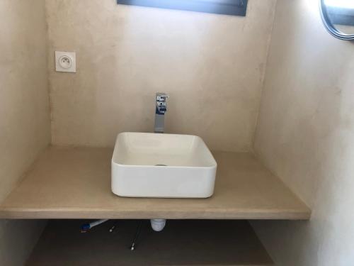a bathroom with a white sink on a counter at Studio indépendant in Spay