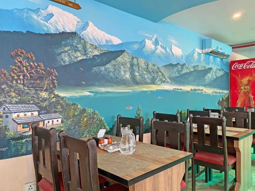 a dining room with a mountain mural on the wall at Hotel Readers Inn Pvt.Ltd in Kathmandu
