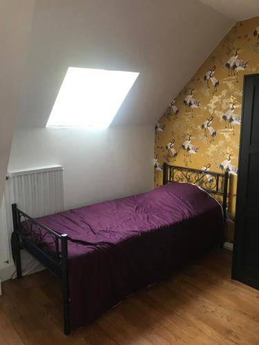 Un dormitorio con una cama con una pared con animales. en Maison cosy au pied du château, en Châteaudun