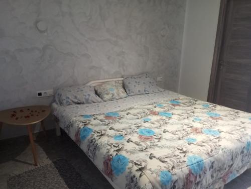 a bedroom with a bed with blue flowers on it at VILLA BELLA VITA HAMMAMET in Hammamet Sud