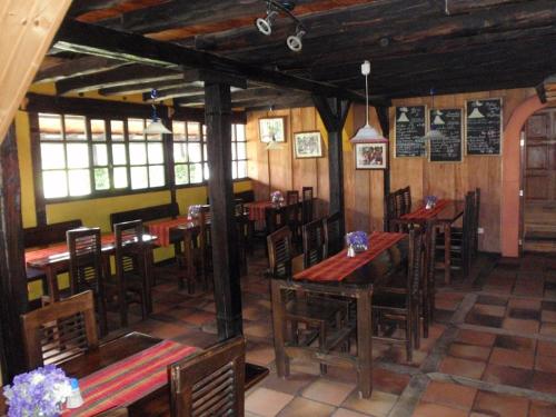 comedor con mesas y sillas de madera en Hostería Hotel Cuello de Luna - Cotopaxi - Country Inn en Lasso