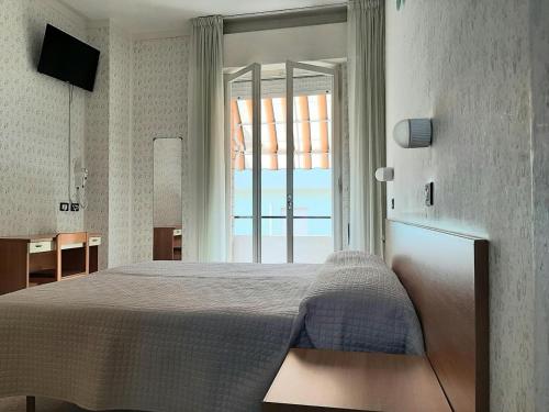 a bedroom with a bed and a large window at Pensione TOSCA B&B Cattolica in Cattolica