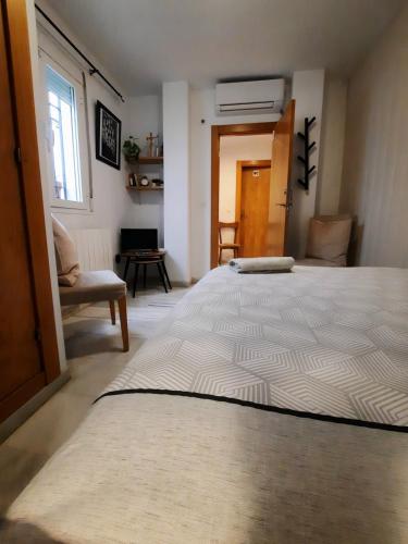 a large white bed in a room with a chair at CASA HONDA10 in Granada