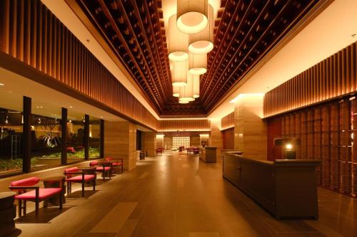 a lobby of a hotel with red chairs and tables at Khách Sạn Wins Apec Mũi Né in Mui Ne