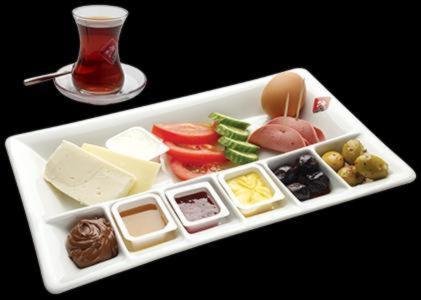 a white tray with different types of cheese and vegetables at Borancik hotel in Istanbul
