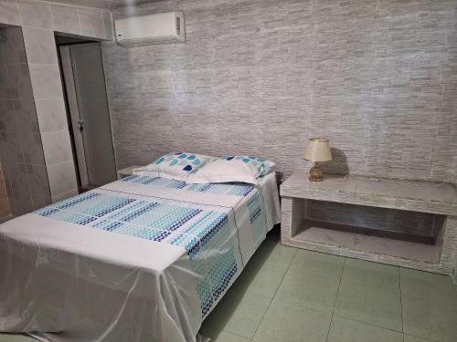 - une petite chambre avec un lit et une table dans l'établissement Paille en queue, à Saint-Leu
