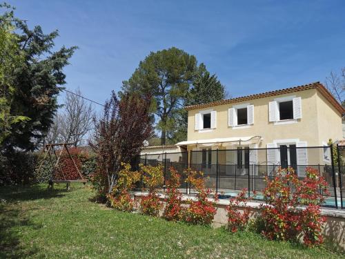 a house with a fence in front of a yard at Studio indépendant à 2 minutes du golf du Luberon in Pierrevert