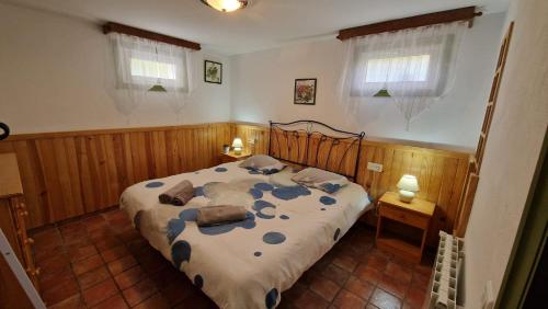 1 dormitorio con 1 cama, 2 mesas y 2 ventanas en El Refugio, en Turís