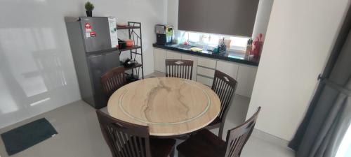 a kitchen with a wooden table with chairs and a refrigerator at Lodge 16 Private Villa in Kuah