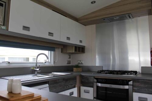 a kitchen with a sink and a stove at HARRIES LODGE QUAY WEST milkwood way in New Quay