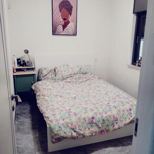 um quarto com uma cama com um edredão floral em ירושלים של זהב em Jerusalém
