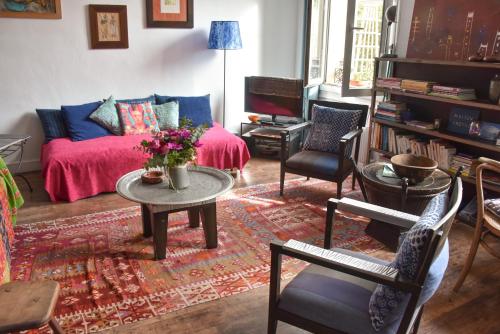 uma sala de estar com um sofá, uma mesa e cadeiras em La Maison d'Elysa em Perpignan