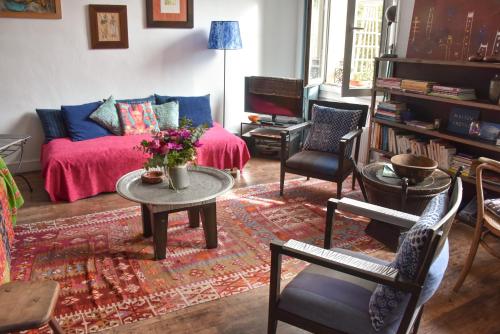 a living room with a couch and a table and chairs at La Maison d'Elysa in Perpignan