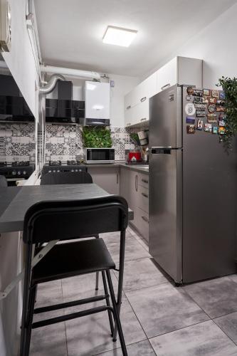 a kitchen with a stainless steel refrigerator and a chair at Modern Studio ground floor & designer lighting in Timişoara
