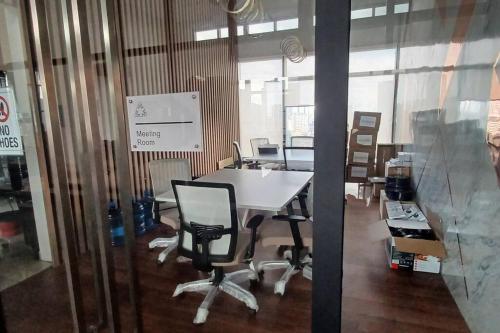 an office with a table and chairs in a room at Aesthetic Urban Suite With Infinite Pool & Gym in Jelutong