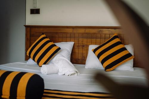 a bed with two pillows and towels on it at Chill Vibes Hiriketiya in Hiriketiya