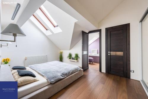 een slaapkamer met een bed en een plafond met dakramen bij Luxusní apartmán s výhledem in Praag