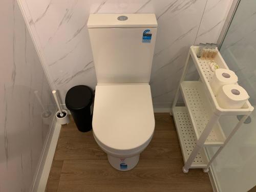 um WC branco numa casa de banho com dois rolos de papel higiénico em The Reserve Hotel em Sale