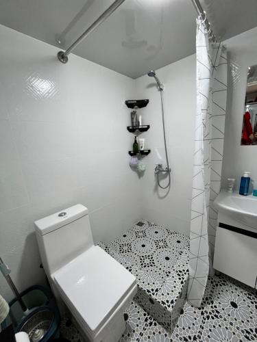Baño blanco con aseo y lavamanos en Апартаменты Tropicana, en Samarkand